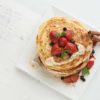 White Plate Full Of Pancakes With Raspberries Strawberries Blueberries And Honey